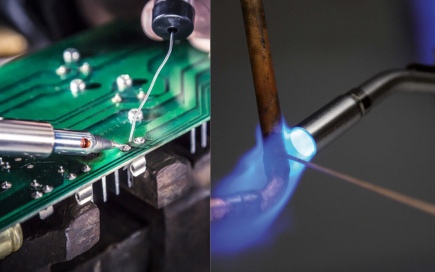 A soldering iron connects a wire to a green circuit board. Beside it, a blowtorch emits a blue flame onto a metal rod, both set in a workshop environment.