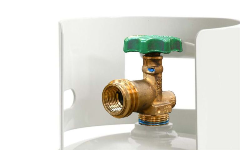 A brass gas valve with a green handle is attached to a white propane tank in a clean, well-lit setting.
